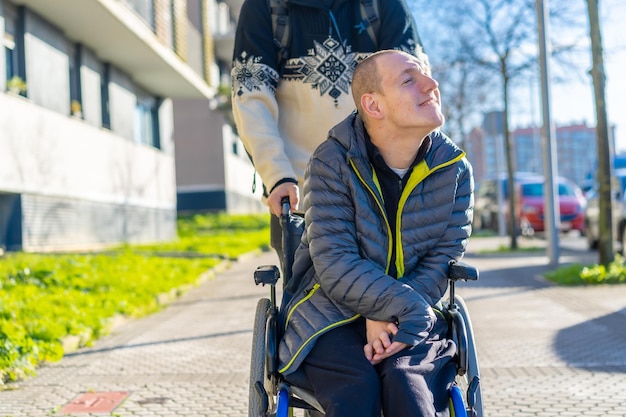 Zdjęcie osoba niepełnosprawna ciesząca się chodzeniem po ulicy w rehabilitacji na wózku inwalidzkim