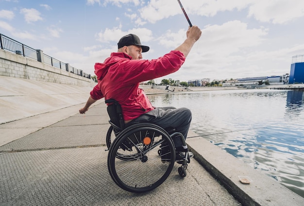 Osoba Niepełnosprawna Fizycznie Na Wózku Inwalidzkim łowiąca Z Molo Rybackiego