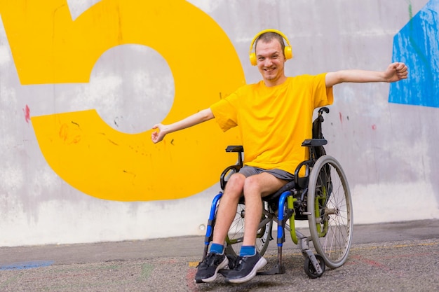 Osoba niepełnosprawna na wózku inwalidzkim słuchająca muzyki na słuchawkach uśmiechnięta
