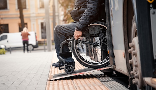 Osoba niepełnosprawna ruchowo wysiada z transportu publicznego z dostępną rampą