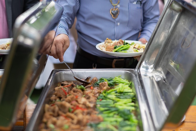 Osoba nosząca rękawiczki nabierająca jedzenie, catering, czas na obiad, zapobiega chorobie koronawirusowej (covid 19)