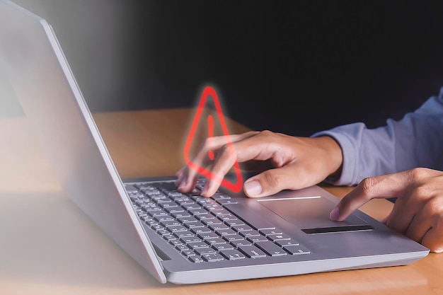 Osoba pisząca na laptopie z czerwoną strzałką na ekranie.