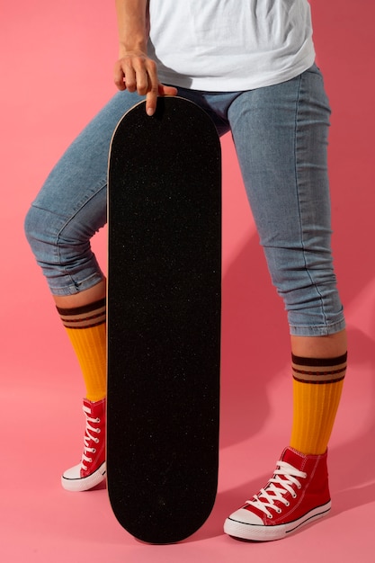 Osoba pozująca ze skateboardem