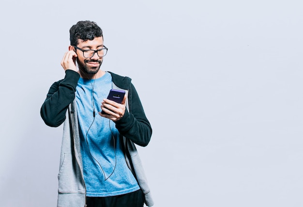 Osoba słuchająca muzyki przez telefon komórkowy ze słuchawkami na białym tle ludzie cieszący się muzyką ze słuchawkami na białym tle wesoły facet słuchający muzyki przez telefon komórkowy na białym tle