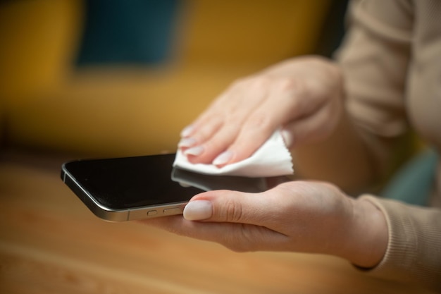 Osoba starannie wyciera ekran smartfonu szmatą, aby usunąć brud i odciski palców