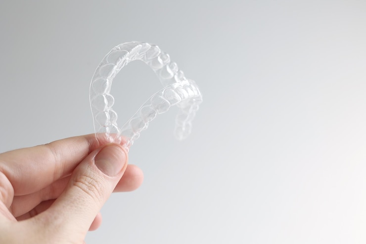 Zdjęcie osoba trzyma w dłoni przezroczystą plastikową klamrę.