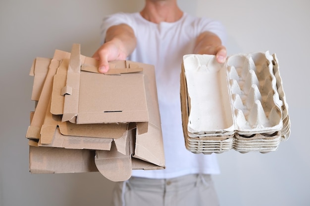 Osoba Trzyma W Rękach Paczki Z Jajkami I Kartony Na Białym Tle, Oddziel Je I Poddaj Recyklingowi