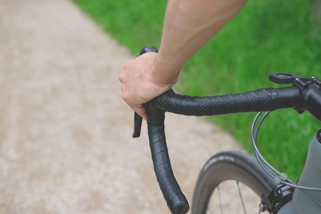 osoba trzymająca kierownicę górnego uchwytu roweru przełajowego z bliska jazda po żwirowej ścieżce