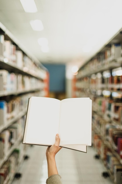 Osoba trzymająca książkę w bibliotece ze słowem „słowo” w lewym górnym rogu.