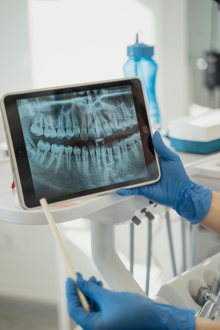 Zdjęcie osoba trzymająca tabletkę z szczoteczką do zębów w ręku
