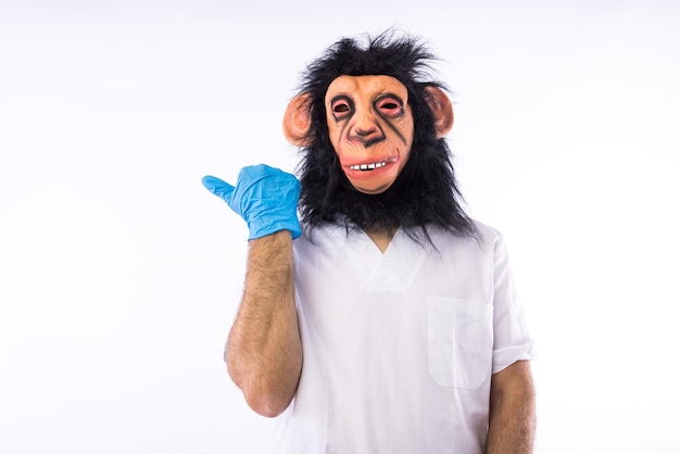 Osoba ubrana w kombinezon z maską ubrana w strój pielęgniarki medycznej wskazujący palcem w bok na białym tle Epidemia wirusa pandemii ospy małpiej Nigeria i koncepcja ospy prawdziwej