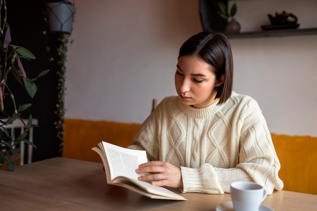 Zdjęcie osoba w kawiarni czytająca książkę przy kawie