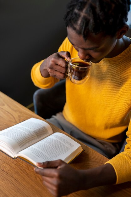 Osoba w kawiarni czytająca książkę