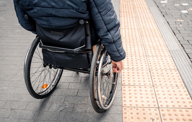 Osoba z niepełnosprawnością ruchową oczekująca na transport miejski z dostępną rampą