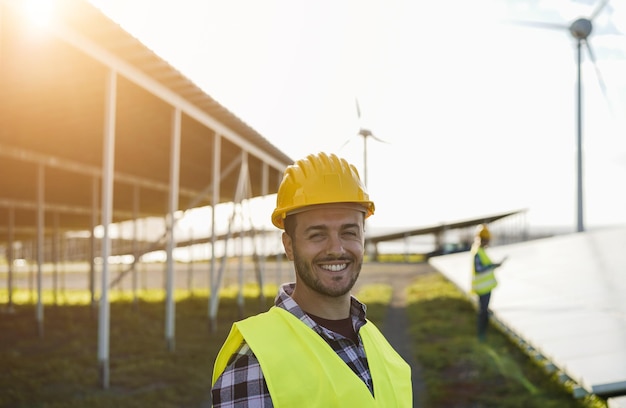 Osoby pracujące dla paneli słonecznych i turbin wiatrowych Koncepcja energii odnawialnej Skoncentruj się na twarzy mężczyzny