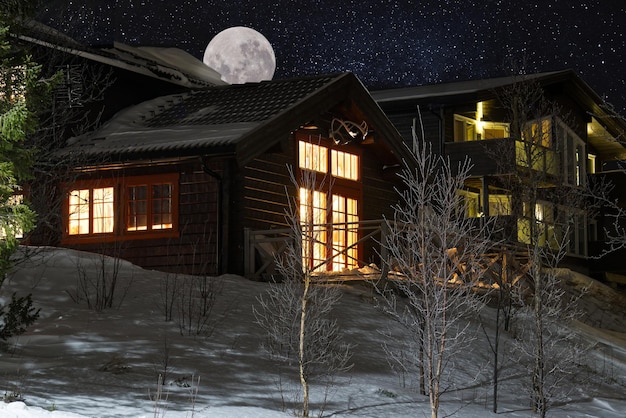 Ośrodek narciarski w nocy szwedzki ośrodek narciarski to w nocy drewniane domki w górach z gwiazdami na niebie