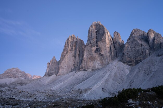 Zdjęcie ostatnie światło dnia oświetla masywne wieże skalne trzech dolomitów we włoszech