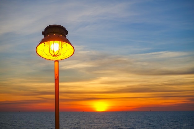 Oświetlenie ciepłej lampy i oświetlenie zachodu słońca na morzu.