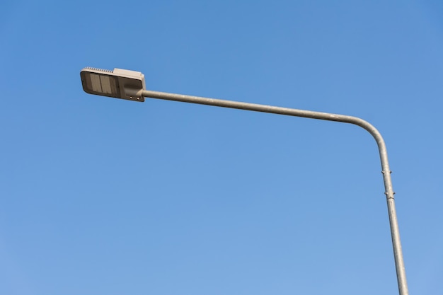 Oświetlenie uliczne LED na stalowym słupie z czystym błękitnym niebem