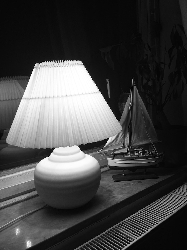 Zdjęcie oświetlona lampa z zabawką na stole w ciemni