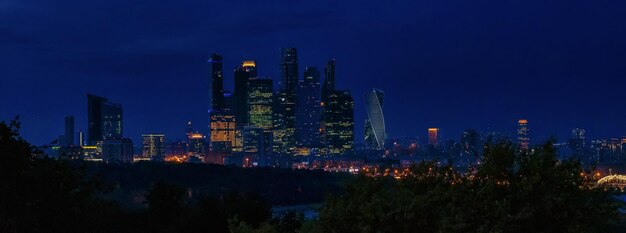 Zdjęcie oświetlone budynki w mieście na tle nocnego nieba