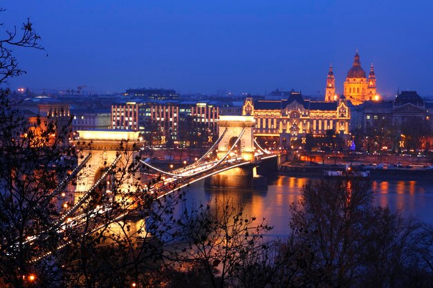 Zdjęcie oświetlony most nad rzeką w mieście w nocy