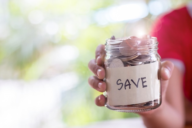 Oszczędności wpłacaj monety w przezroczystej szklanej butelce