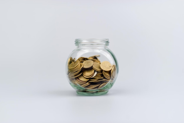 Oszczędzanie monet w szklanym słoiku bank monet inwestycje finansowe dochód płace fundusze inwestycyjne przepływ pieniężny