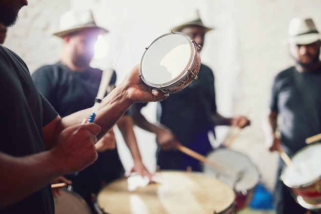 Oto rytmy brazylijskie ujęcie z bliska przedstawiające wykonawcę muzycznego grającego na perkusji ze swoim zespołem