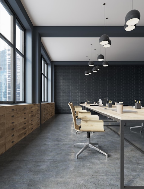 Otwarta przestrzeń biurowa z czarnej cegły z betonową podłogą, dużymi oknami, drewnianymi stołami i krzesłami oraz szufladami. renderowania 3D