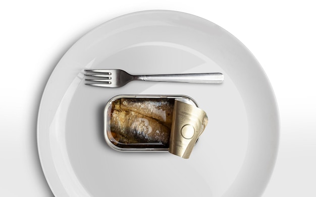 Otwarta puszka konserwowa z sardynek i srebrny widelec na białym talerzu