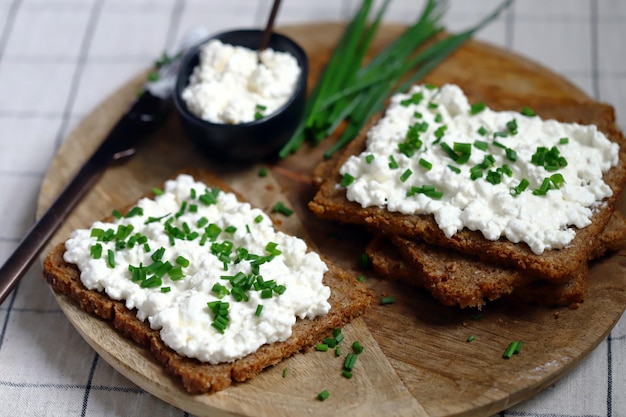 Zdjęcie otwarte kanapki z chlebem żytnim i białym twarogiem z zieloną cebulą zdrowe śniadanie lub przekąska