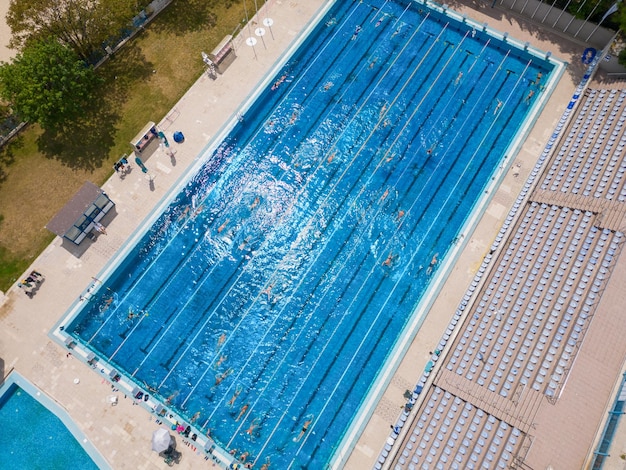 Otwarty basen sportowy lśnił w jasnym słońcu, gdy ludzie kąpali się w zachęcających wodach