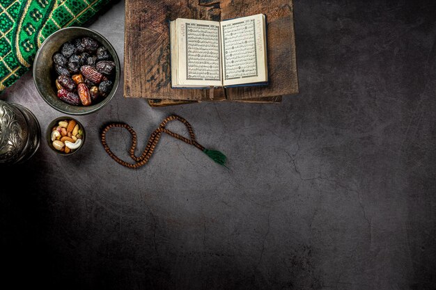 Otwarty koran w pobliżu dat koncepcji ramadan kareem na ciemnym tle z teksturą