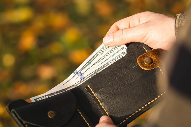 Otwarty portfel z banknotami w rękach mężczyzn