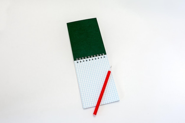 Otwarty pusty notatnik i czerwony długopis na białym tle