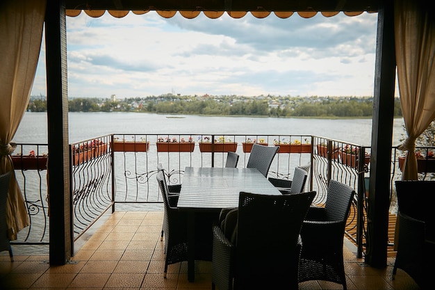Zdjęcie otwarty taras w pustej letniej kawiarni z widokiem na rzekę