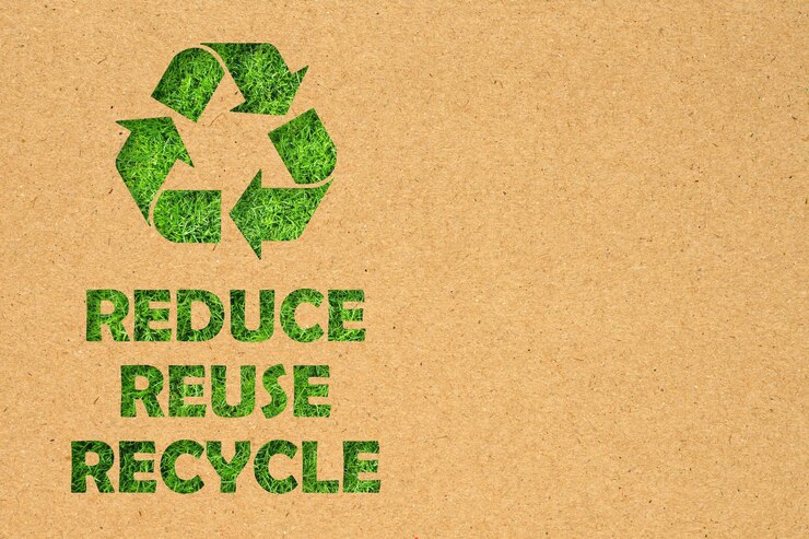 Zdjęcie otwór papieru kraft ponownego użycia zmniejsz symbol recyklingu i tekst na tle zielonej trawy