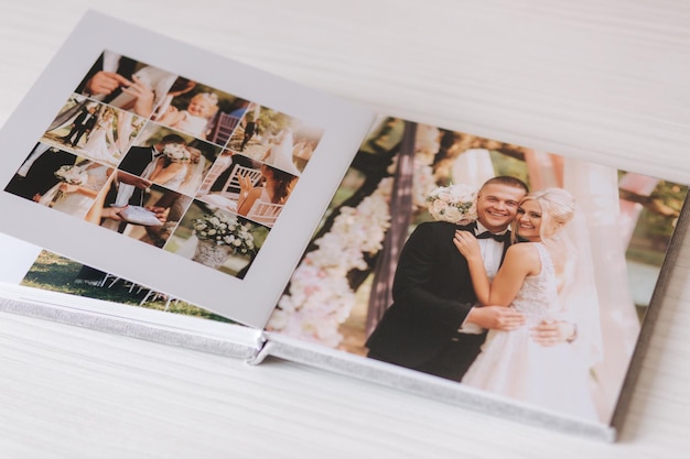 Zdjęcie otwórz fotoksiążkę z wrdding zdjęciem pięknej pary na białym drewnianym stole