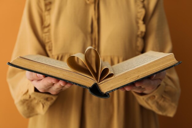 Otwórz książkę w kobiecych rękach na żółtym tle