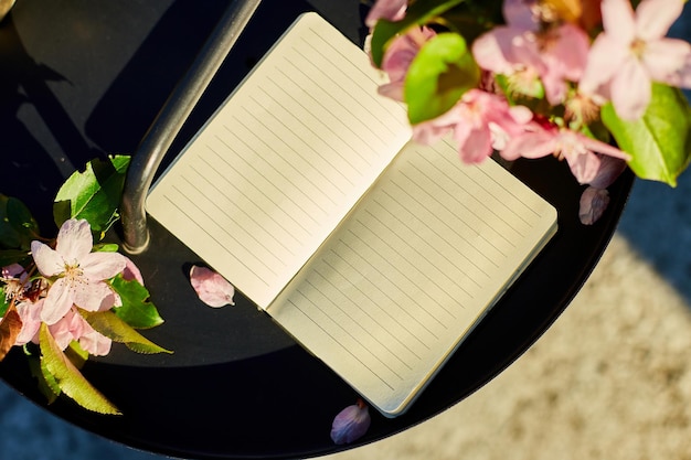 Otwórz notatnik i kwiaty oraz na małym czarnym stoliku na tarasie