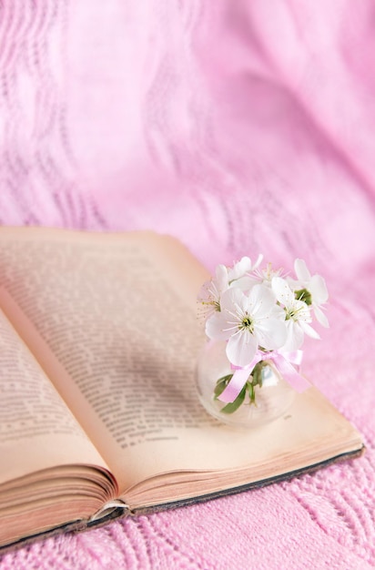 Otwórz starą książkę z białymi małymi kwiatami na różowym tle