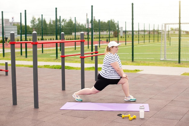 Otyła kobieta uprawia sport na publicznym boisku sportowym w parku Utrata masy ciała jest pozytywna i neutralna