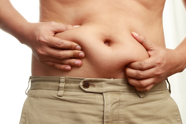 Zdjęcie otyli mężczyźni mają nadmiar tłuszczu, jest na diecie, aby schudnąć.