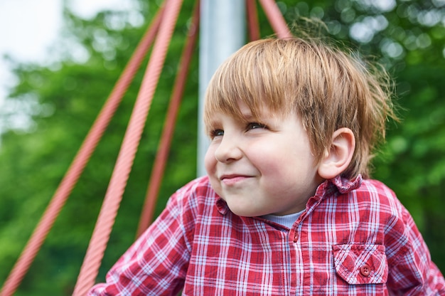 Outdoors portret śliczna preschool chłopiec przy boiskiem na naturalnej zieleni