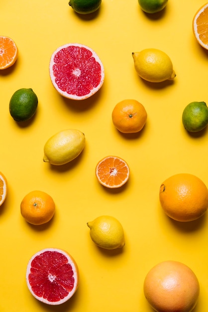 Owoce cytrusowe grejpfrut cytryna limonka pomarańcza na żółtym tle