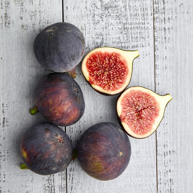 Owoce figowe z czerwonymi dojrzałymi połówkami na drewnianym stole z góry