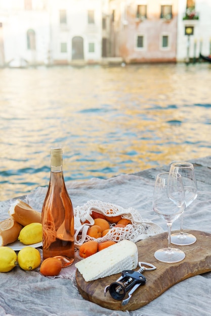 Owoce i przekąski wina różowego na drewnianym molo podczas malowniczego pikniku na drewnianym doku