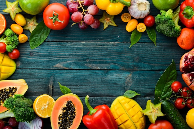 Zdjęcie owoce i warzywa na niebieskim tle drewnianych tło żywności widok z góry wolne miejsce na tekst