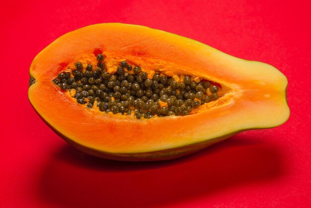 Zdjęcie owoce papai na pomarańczowym tle. owoc tropikalny. połowa papai.